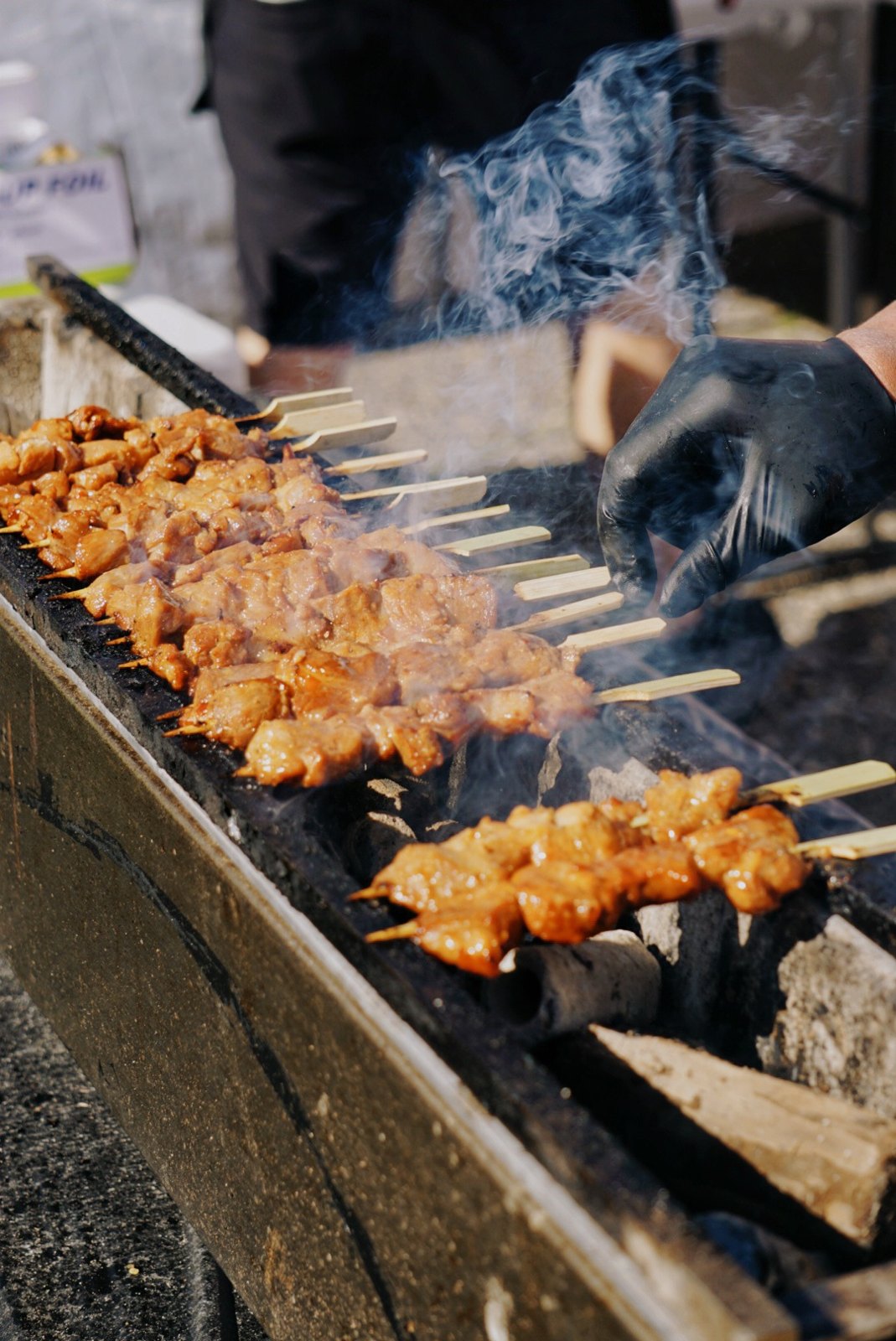 Skewers cooking over a grill at Asian Street Food Night Market